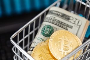 Monety bitcoin i plik dolarów w wózku na zakupy