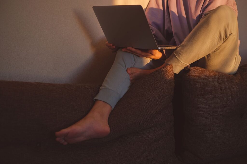 Osoba sprawdzająca stronę internetową na laptopie w domu